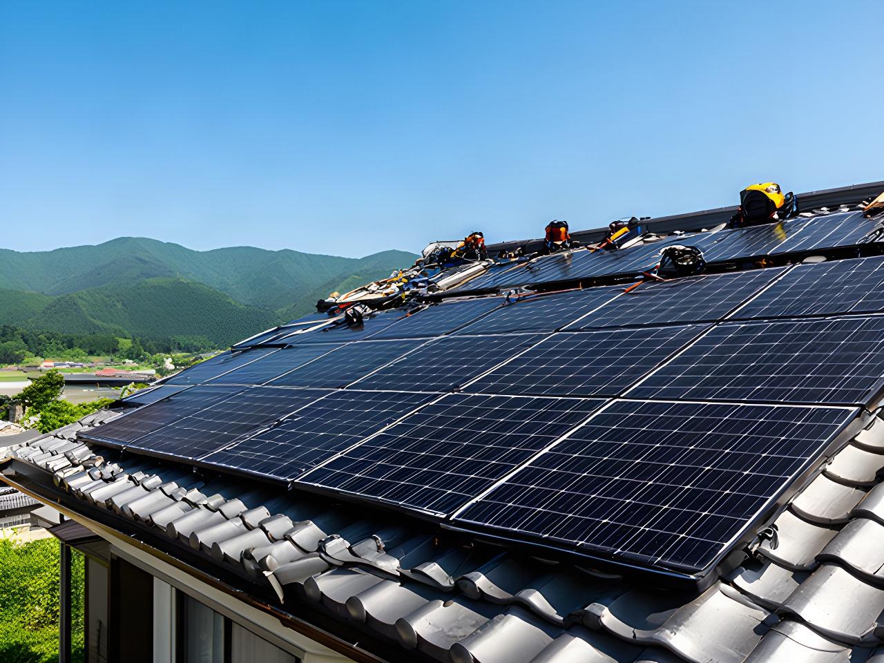 長野県の住宅屋根に太陽光パネルを設置する施工現場と青空